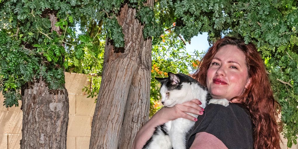 Sonora under a tree holding her cat