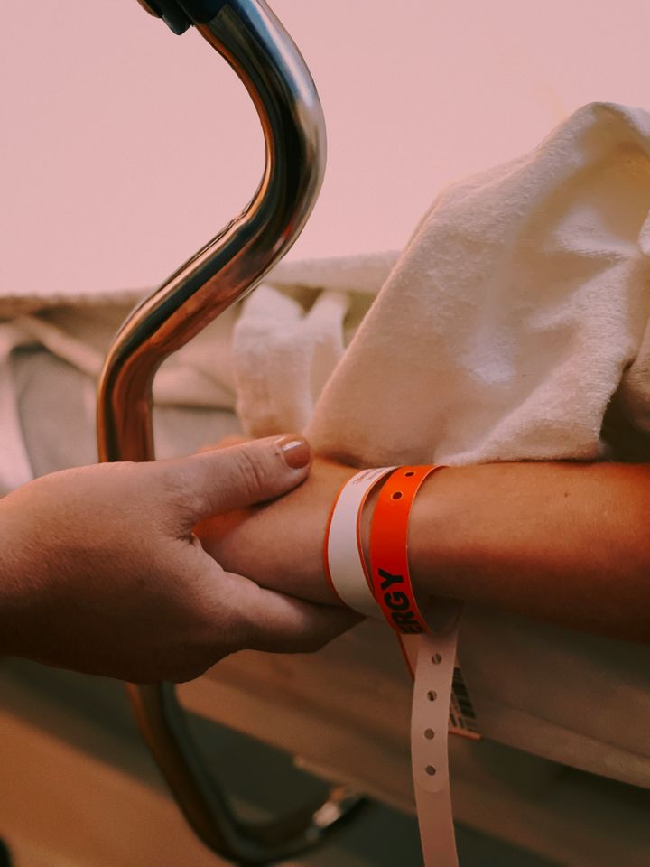 Hands holding in a hospital bed